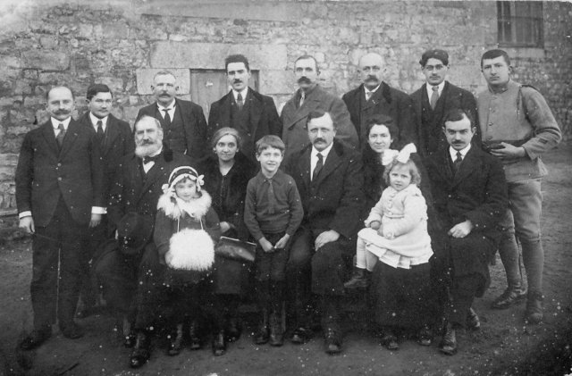 1920. Le Principal (M. Chardon, debout à gauche) et les professeurs (MM. Exmelin, Rougeyron, Carrel, Lebis, Chevarin), avec femmes et enfants.
