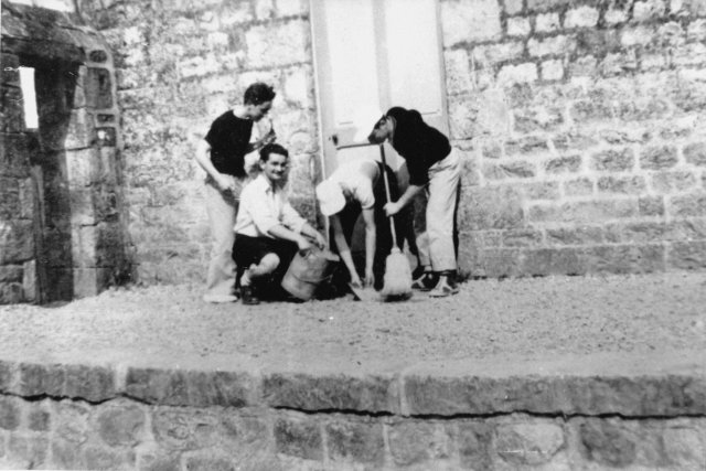 1951-1952. De g. à dr., les élèves Leroyer, Duval, Legoué et Masseron nettoient le perron devant l'actuelle salle 109.
