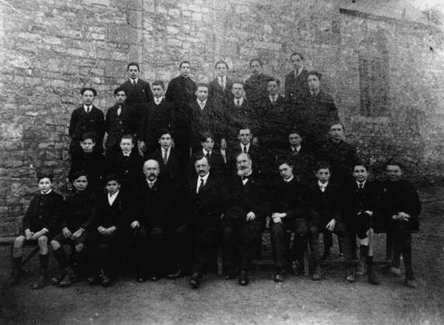 Photo de classe prise en 1919 où, aux côtés de M. Chardon, Principal du Collège de Domfront (au centre), on reconnait M. Carrel (à sa droite) et M. Exmelin (à sa gauche). 